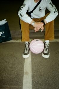 Man with a pink basketball sitting in a Moscow parking lot.