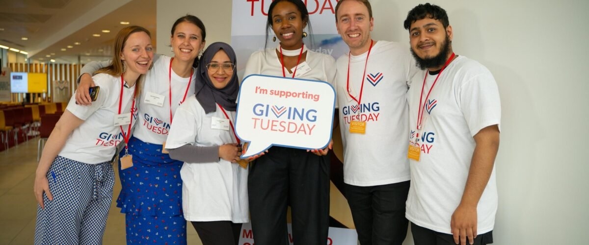 pexels-photo-9826021-9826021 Diverse group of adults supporting Giving Tuesday with enthusiasm indoors.