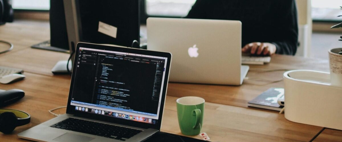 pexels-photo-2102416-2102416 A web developer working on code in a modern office setting with multiple devices.